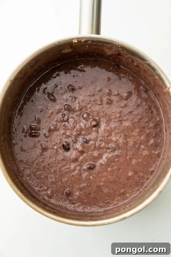 Speedy Black Bean Bliss 4 Close-up of black bean soup cooking, showing its creamy texture.