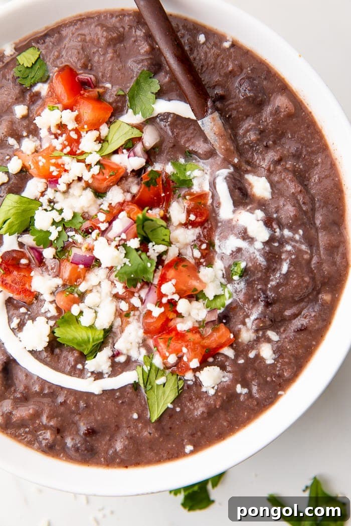 Speedy Black Bean Bliss 5 A vibrant close-up of a bowl of easy black bean soup garnished with fresh cilantro and a dollop of sour cream.