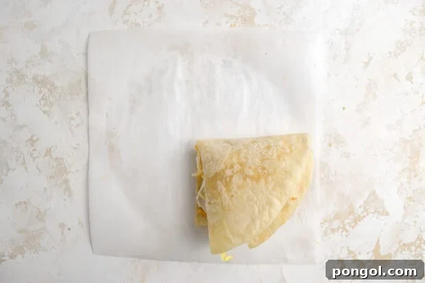 Final fold of the tortilla hack, creating a compact square crunchwrap with all fillings secured