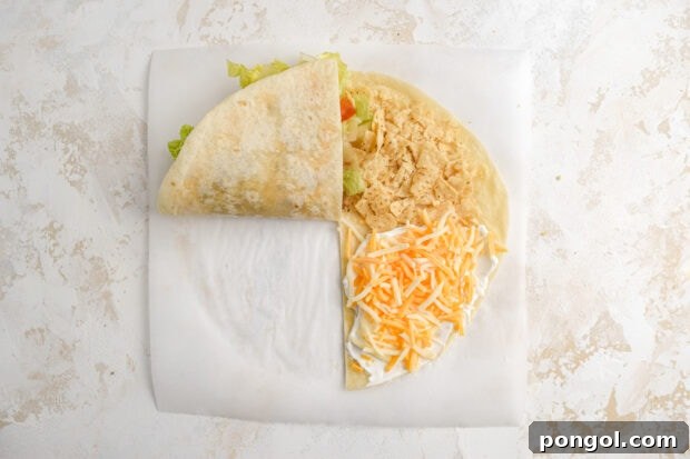 First fold of the tortilla hack, with the beef and cheese quadrant folded onto the lettuce and tomato quadrant