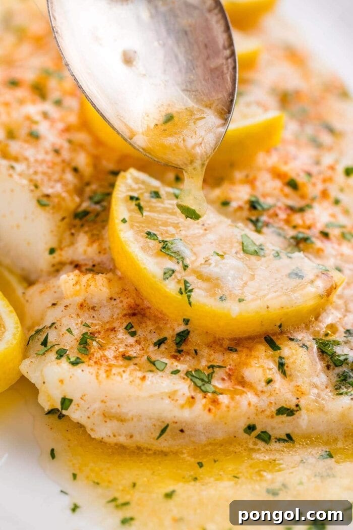 A close up of lemon garlic butter spooned over baked fish