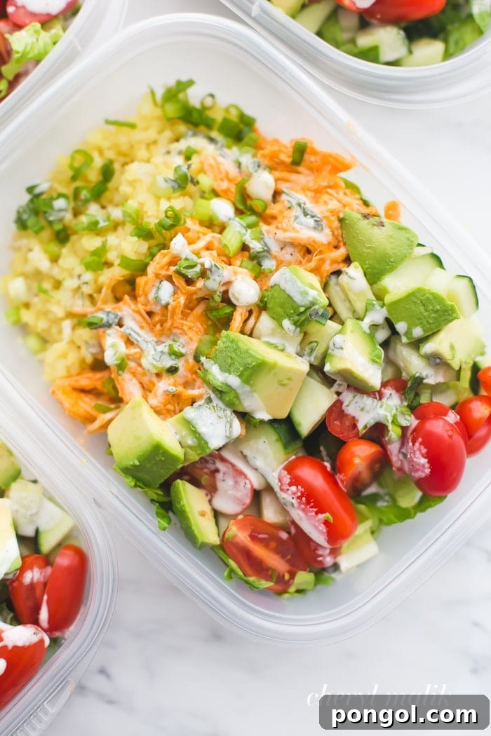 Buffalo chicken meal prep with avocado, cauliflower rice, and ranch dressing in container
