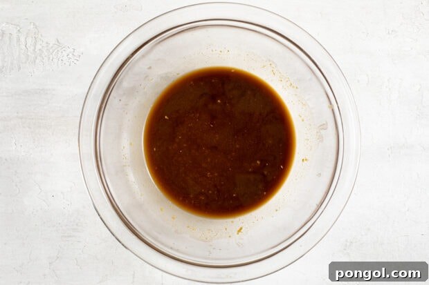 Ingredients for the dressing, including miso paste, soy sauce, rice vinegar, and grated ginger, mixed in a small bowl.