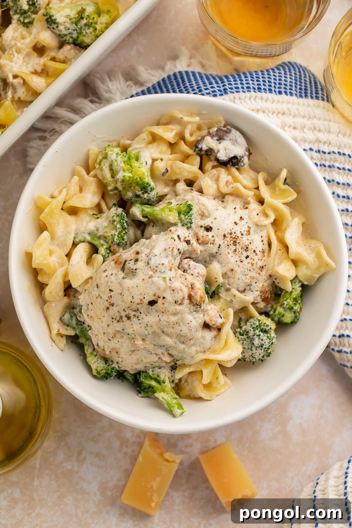 Golden chicken divan with broccoli florets and egg noodles covered in creamy sour cream sauce, ready to be served.