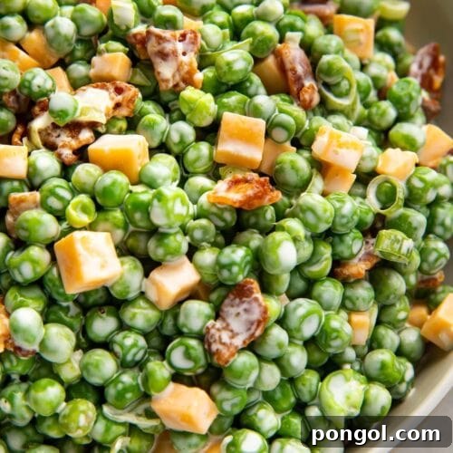 Pea salad with bacon, cheddar, and green onions in a large bowl