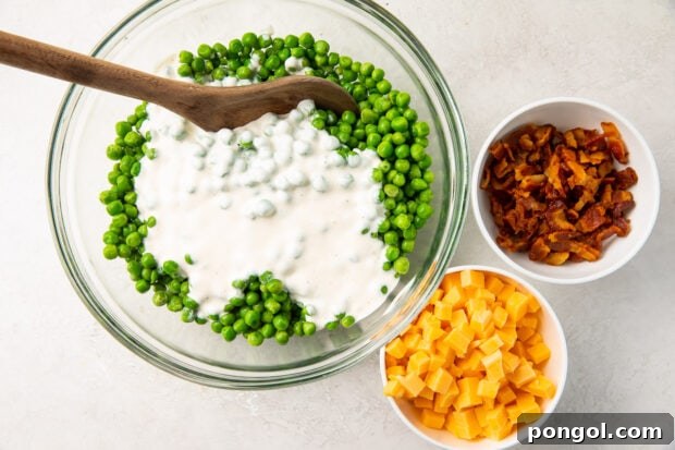 Ingredients for pea salad in bowls, including thawed peas and dressing components.