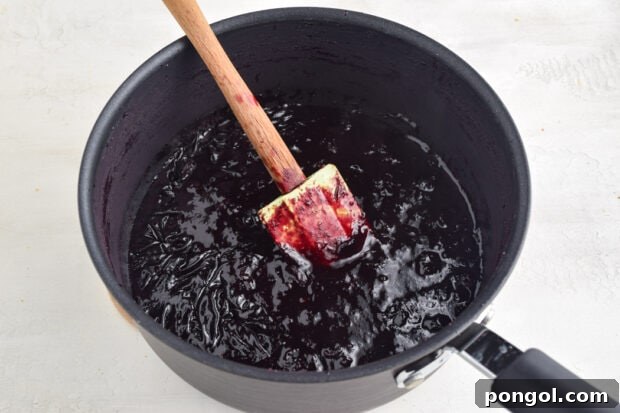Blueberry Jam Process Photo 2: Simmering jam thickening in the pan