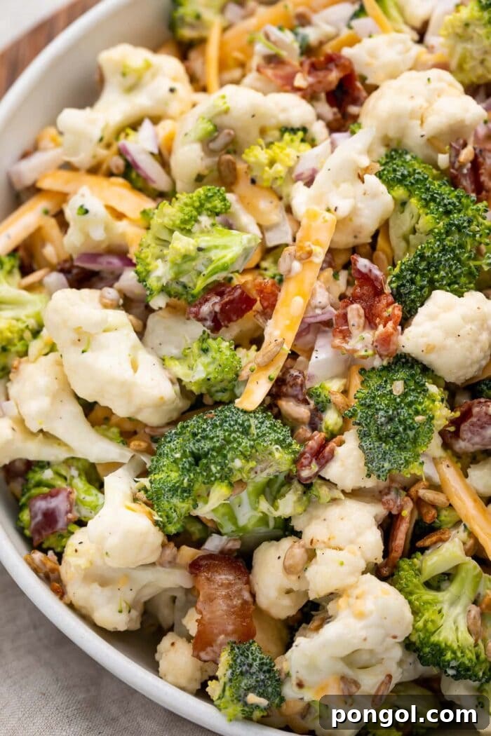 Close up of broccoli cauliflower salad, showcasing its fresh ingredients and creamy texture.