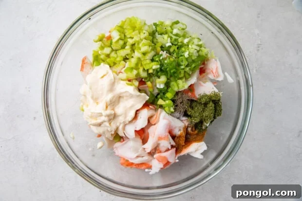 Ingredients for crab salad in a glass mixing bowl