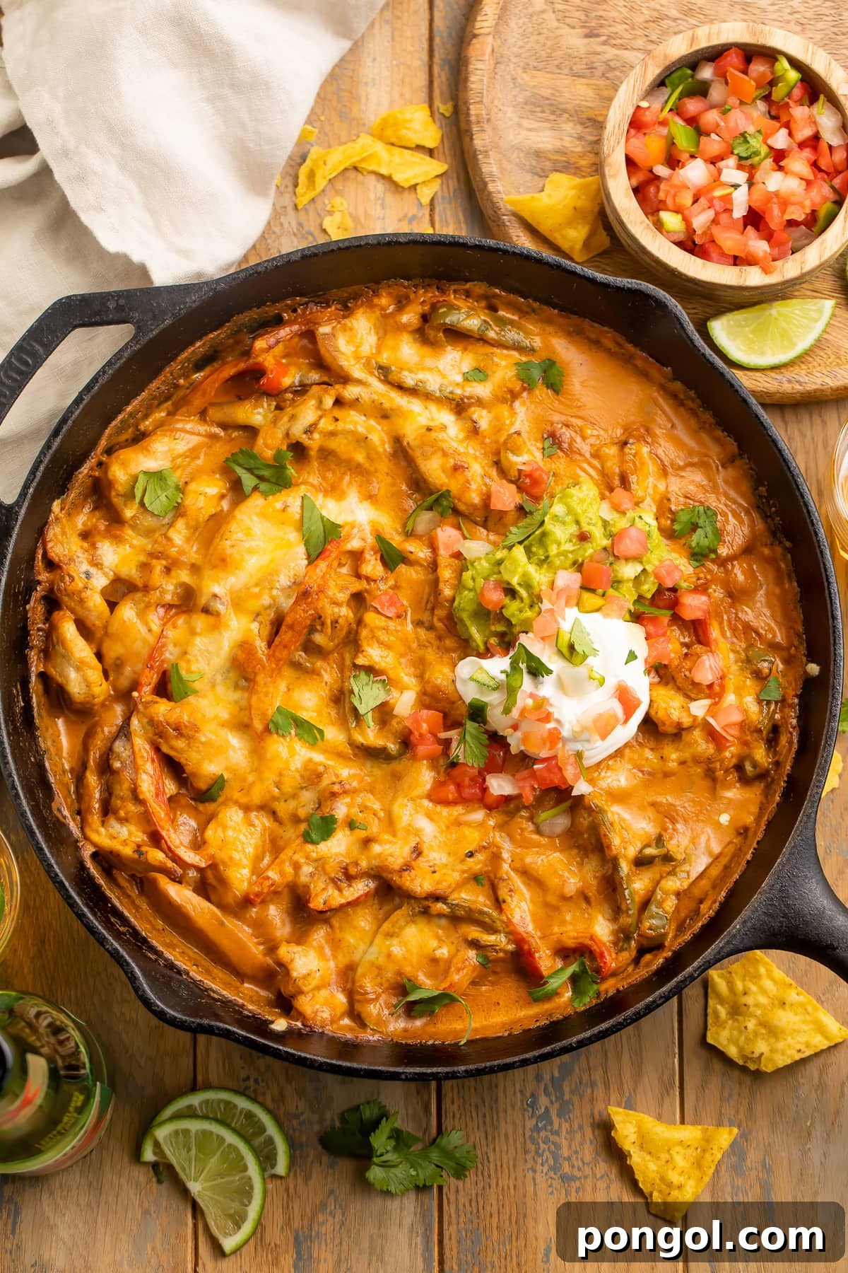 Mexican Chicken Extravaganza 8 Chicken fajita casserole with a creamy sauce and a dollop of sour cream in a cast-iron skillet.
