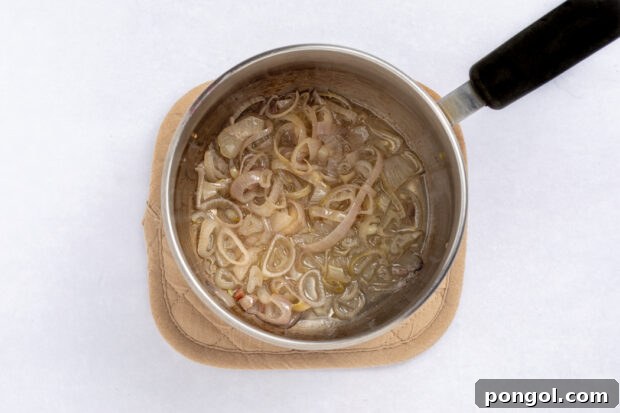 Shallots cooking in bacon fat for the dressing.