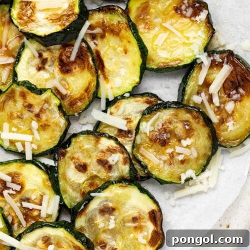 Overhead image of air fried zucchini slices with parmesan cheese on top.
