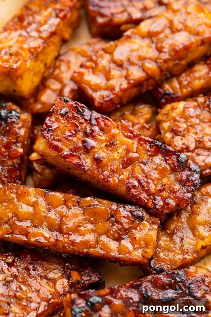 Crispy tempeh bacon strips arranged on a wooden board