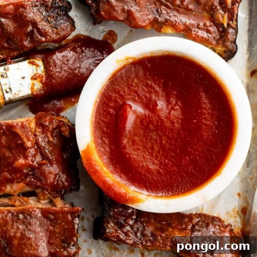 A small bowl of keto bbq sauce surrounded by pulled pork