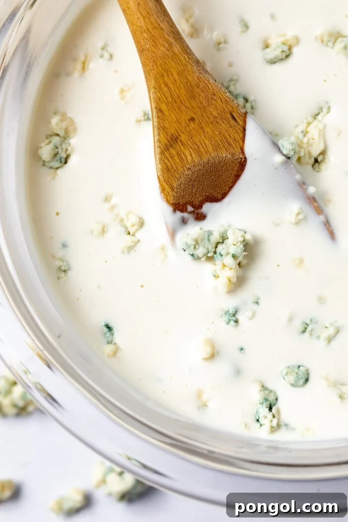Bold Roquefort Dressing 2 Roquefort dressing in a bowl with a wooden spoon, ready to be served.