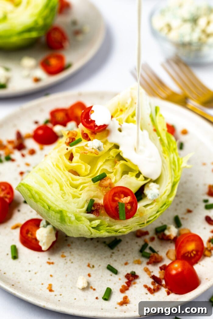 Bold Roquefort Dressing 3 Roquefort dressing being poured over a crisp wedge salad, showcasing its creamy texture.