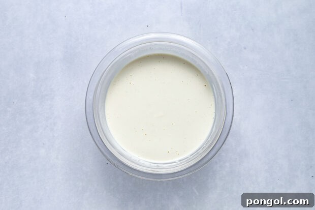 Bold Roquefort Dressing 5 All liquid ingredients for Roquefort dressing being whisked in a bowl.