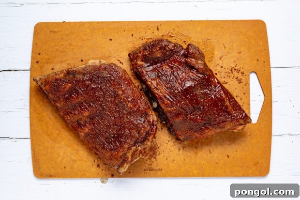 Brushing ribs with barbecue sauce before grilling.