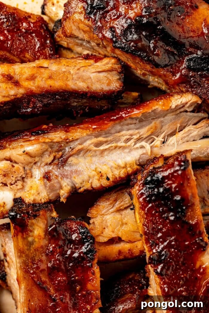 Close-up image of perfectly charred, sliced sous vide ribs glazed with barbecue sauce.