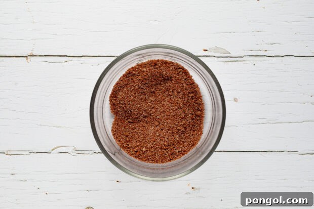 Applying dry rub to baby back ribs.