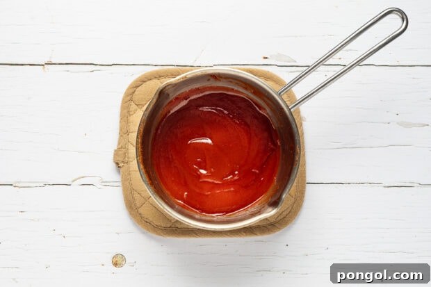 Cooking homemade barbecue sauce in a saucepan.