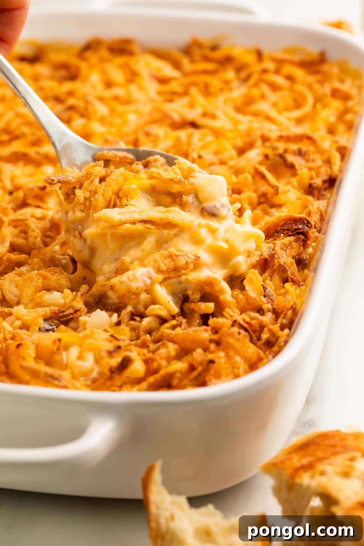 125 Simple Chicken Dinners: Fast Meals with Pantry Staples 119 A spoonful of ultimate chicken casserole being lifted out of a casserole dish.