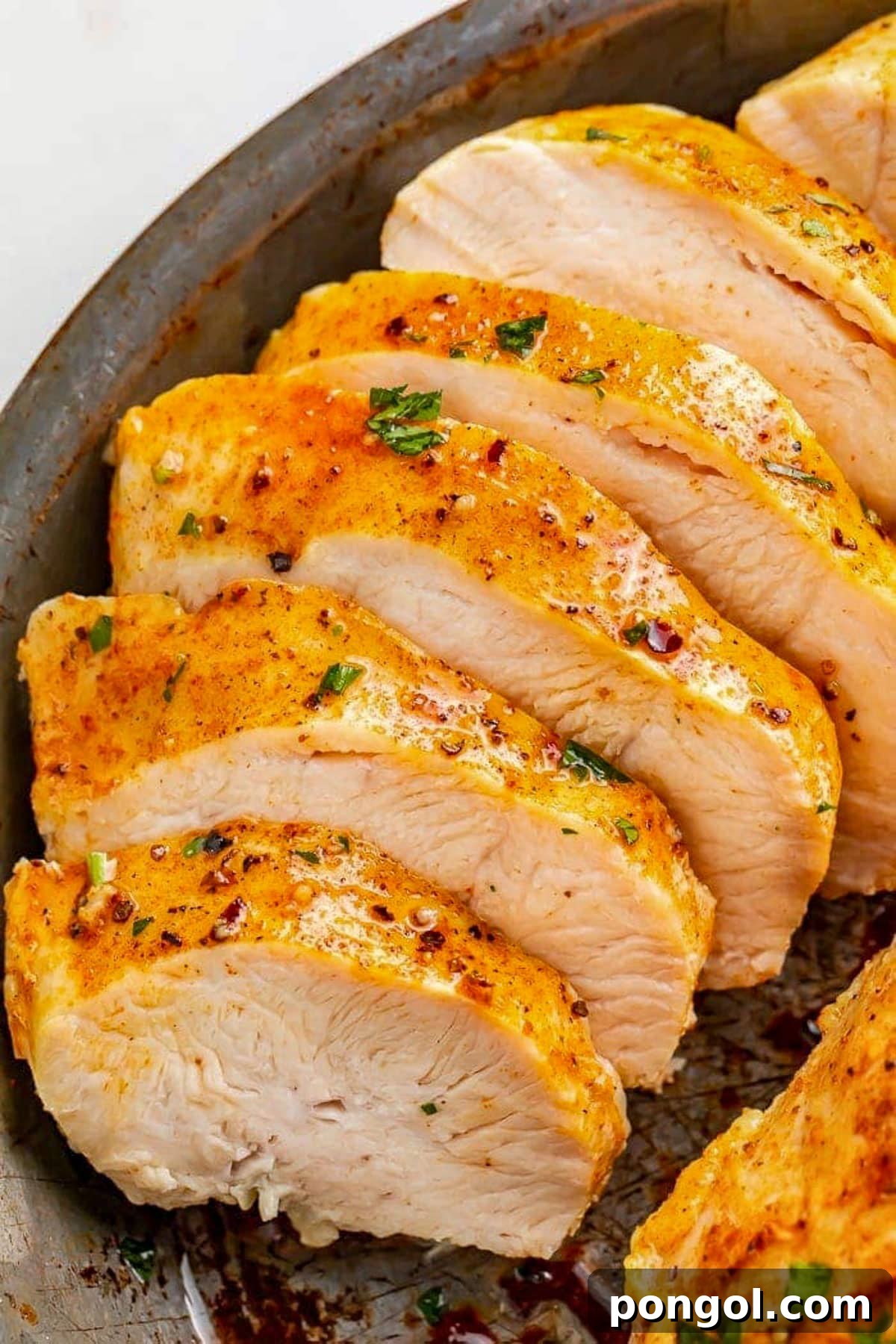 125 Simple Chicken Dinners: Fast Meals with Pantry Staples 3 Sliced Instant Pot frozen chicken breast on a dark grey plate.
