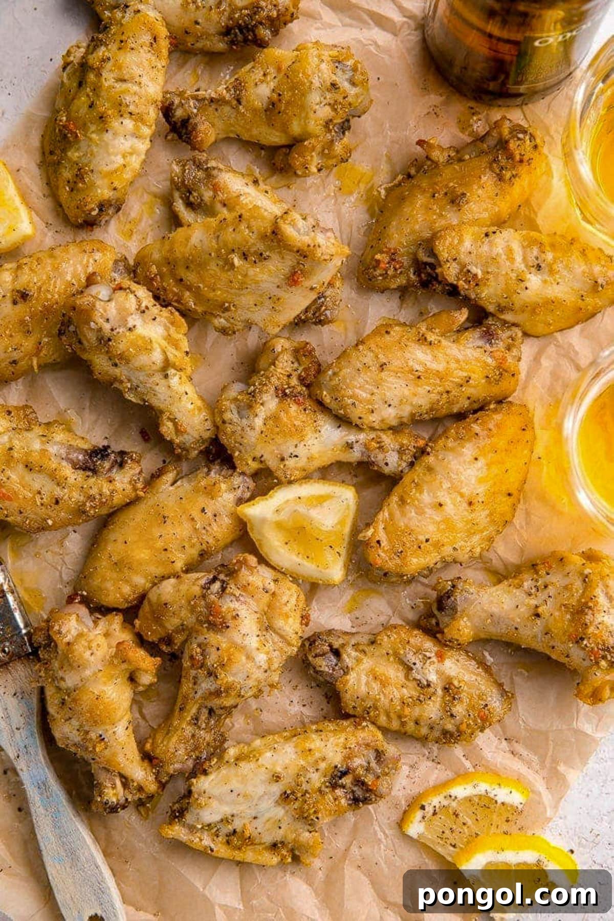 125 Simple Chicken Dinners: Fast Meals with Pantry Staples 29 Lemon pepper seasoned chicken wings on a baking sheet lined with parchment paper.