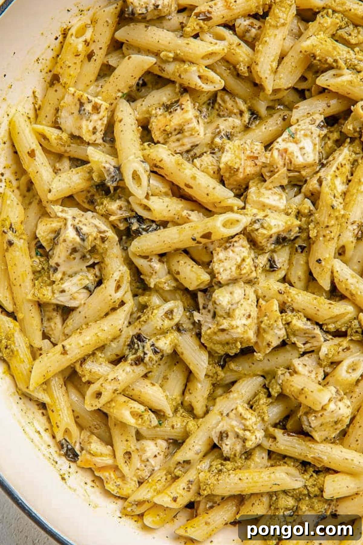 125 Simple Chicken Dinners: Fast Meals with Pantry Staples 33 Close up of pesto penne pasta with grilled chicken in a large pot.