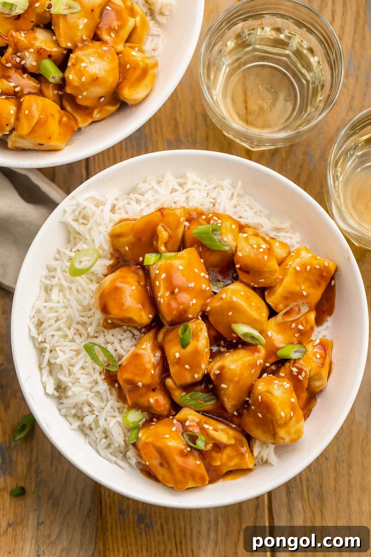 125 Simple Chicken Dinners: Fast Meals with Pantry Staples 49 Two bowls holding white rice and cubed chicken in honey garlic sauce and cooked in the Instant Pot.