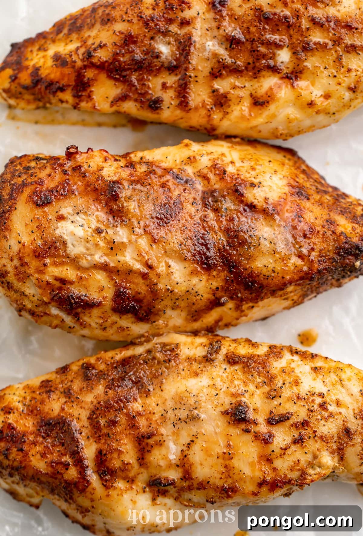 125 Simple Chicken Dinners: Fast Meals with Pantry Staples 6 Three previously-frozen chicken breasts cooked in the air fryer then placed side-by-side on a plate.