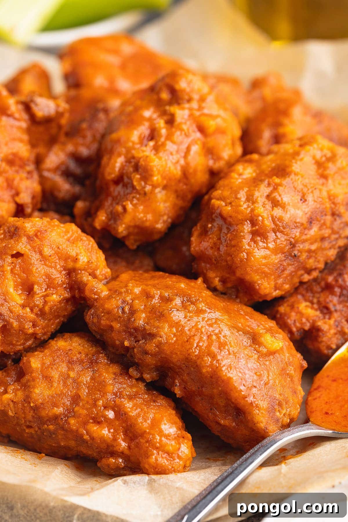 125 Simple Chicken Dinners: Fast Meals with Pantry Staples 59 A pile of boneless buffalo chicken wings in a shallow bowl lined with parchment paper.