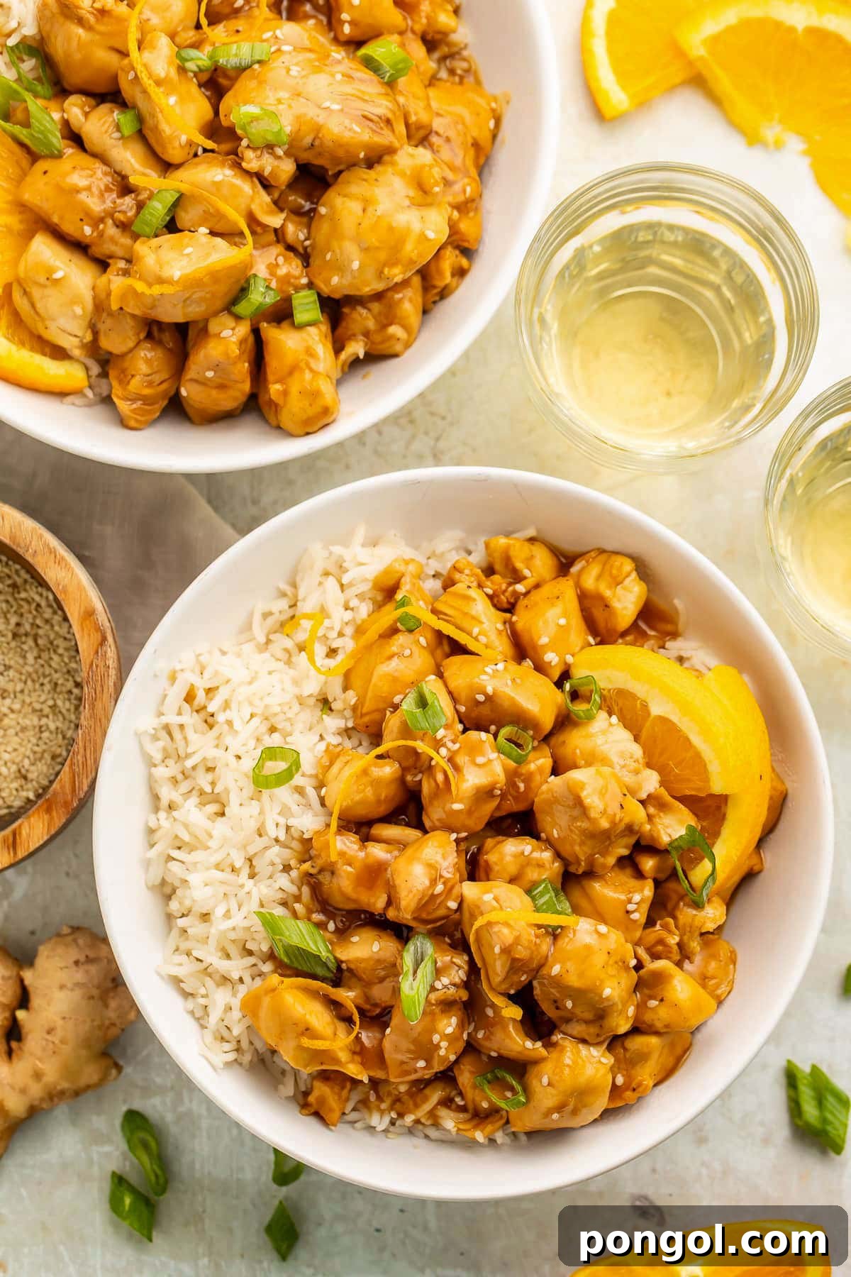 125 Simple Chicken Dinners: Fast Meals with Pantry Staples 61 Top-down view of two bowls holding white rice and glazed orange chicken cooked in the Instant Pot.