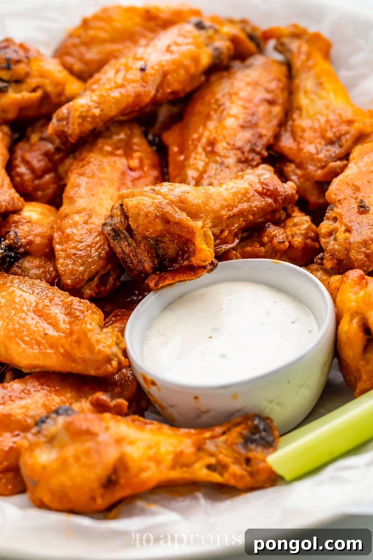 125 Simple Chicken Dinners: Fast Meals with Pantry Staples 66 A platter of Whole30 buffalo chicken wings with a small dipping bowl of Whole30 ranch dressing and celery sticks.