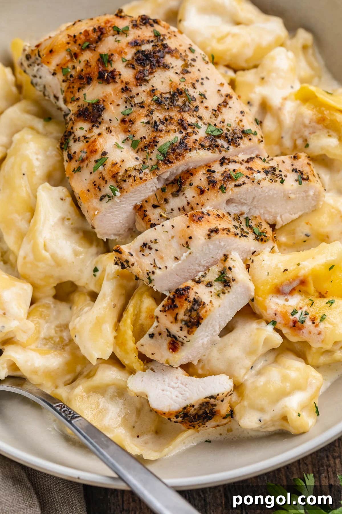 125 Simple Chicken Dinners: Fast Meals with Pantry Staples 77 Creamy asiago tortelloni topped with slices of grilled chicken.