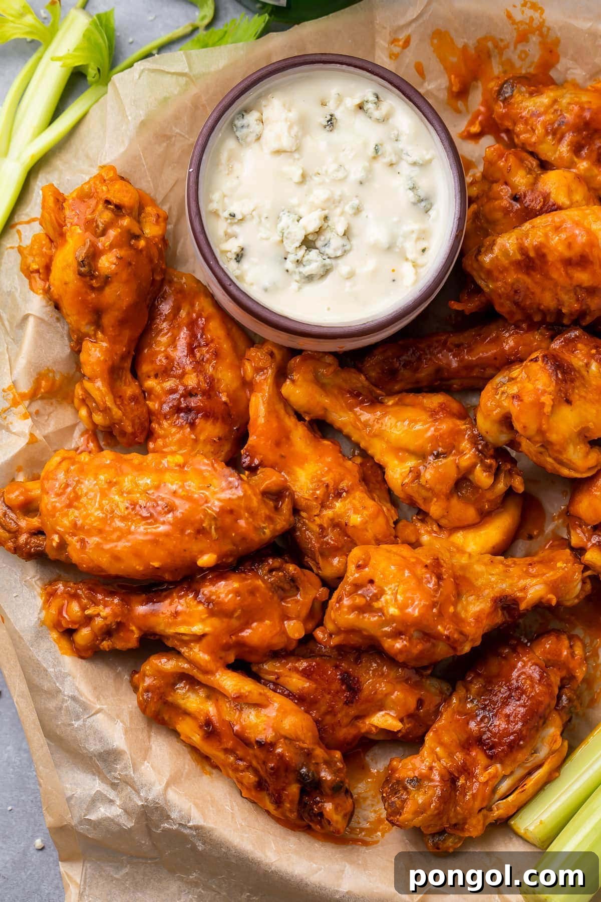 125 Simple Chicken Dinners: Fast Meals with Pantry Staples 93 A plate of buffalo orange chicken wings cooked in an Instant Pot and plated with a small ramekin of ranch dressing.