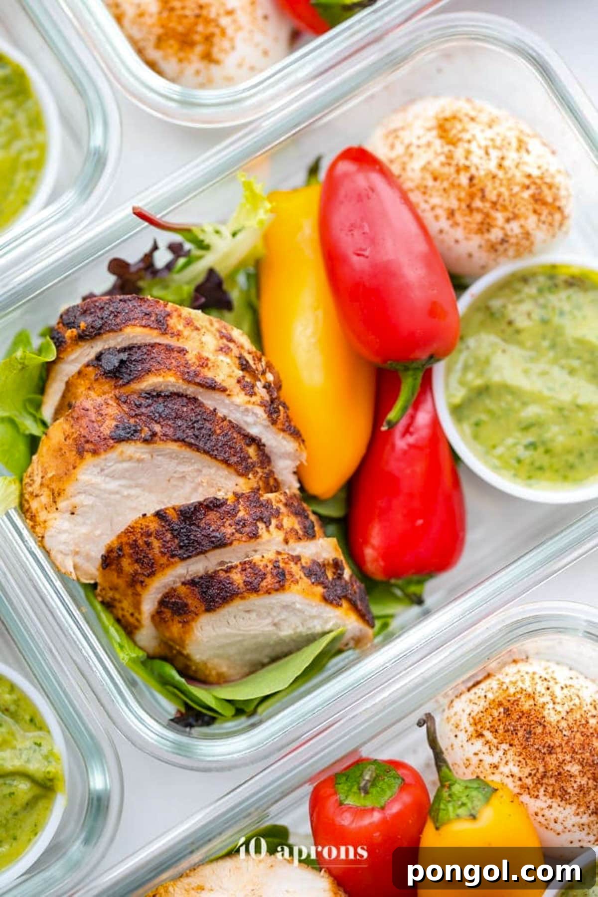 125 Simple Chicken Dinners: Fast Meals with Pantry Staples 96 A glass meal prep container with sliced grilled chicken, bright red and yellow peppers, guacamole, and a bed of lettuce.