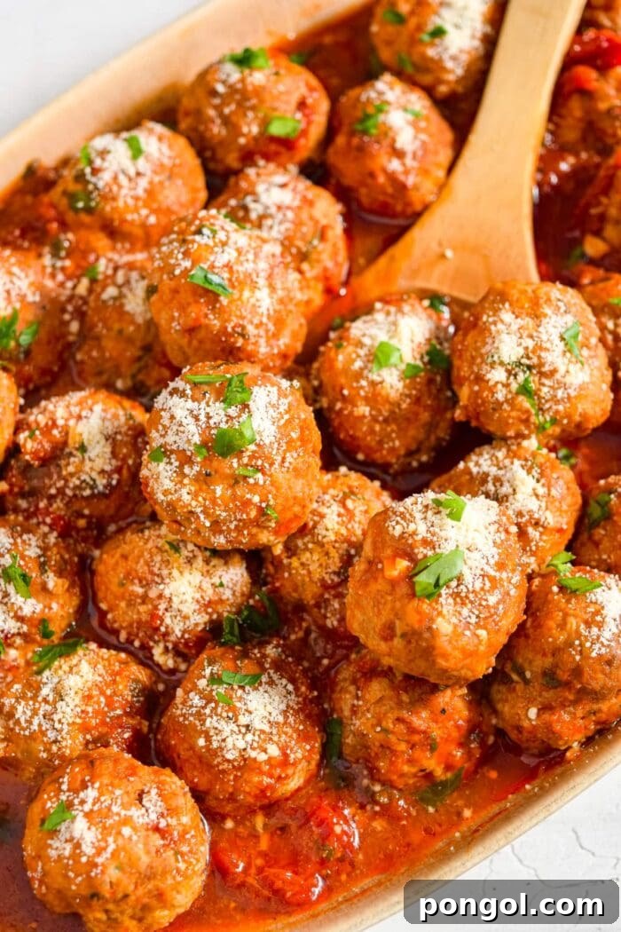 Close up image of instant pot meatballs in a serving dish with a wooden spoon.