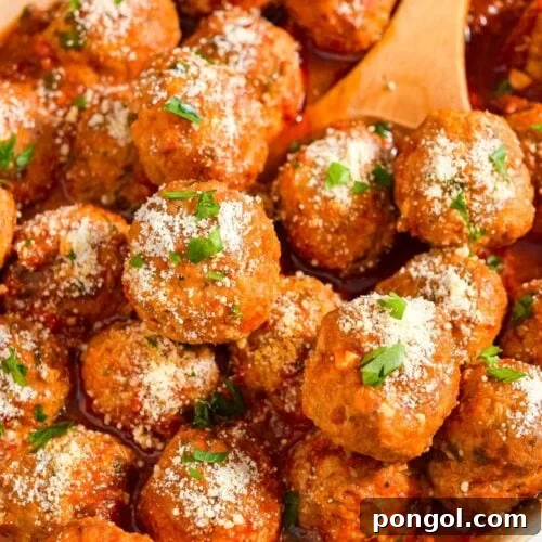 Close up image of instant pot meatballs in a serving dish with a wooden spoon.