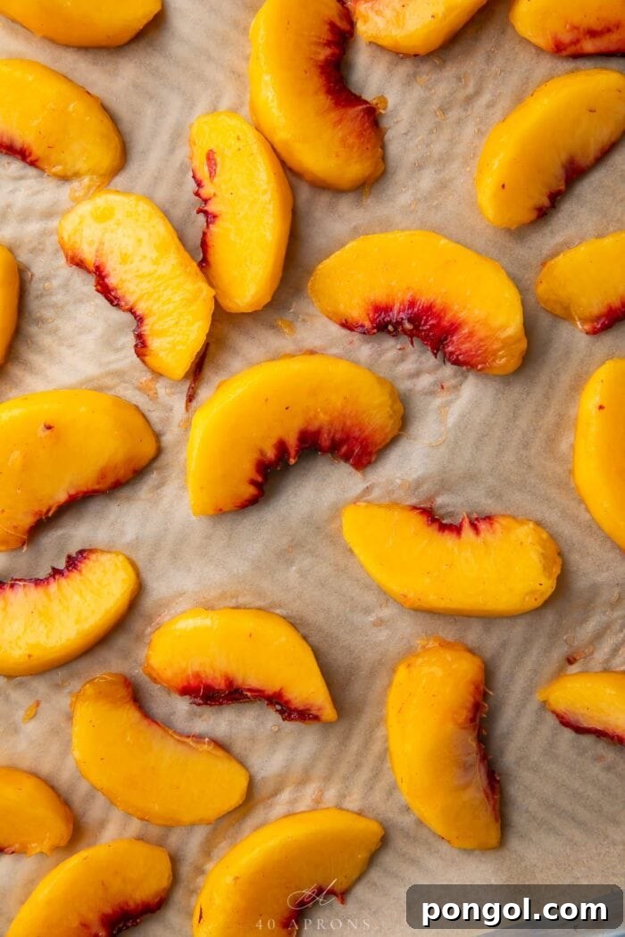 Peach wedges on a baking sheet lined with parchment paper