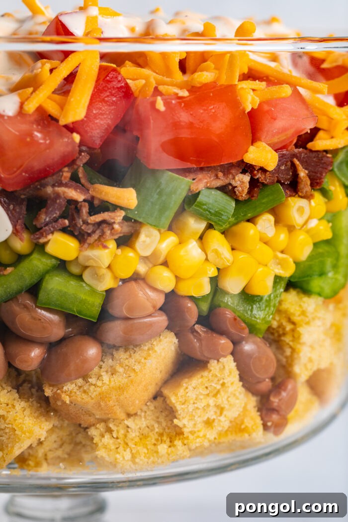 Close up image of cornbread salad layered in a dish.