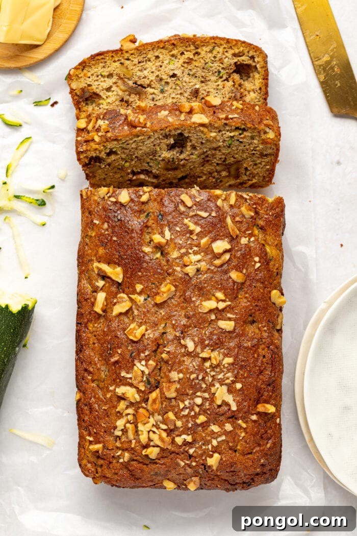 overhead image of keto zucchini bread surrounded by butter, shredded zucchini and a knife