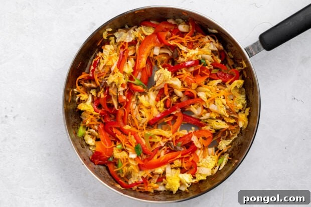Wok-Tossed Beef Noodles 9 Assorted julienned vegetables, including carrots, bell peppers, mushrooms, and cabbage, stir-frying in a wok.