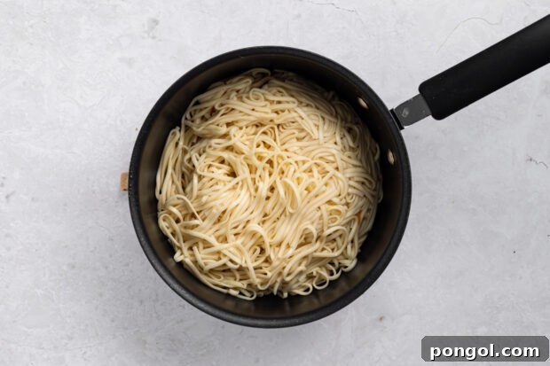 Wok-Tossed Beef Noodles 5 Cooked lo mein noodles in a colander, ready for the next step of the recipe.