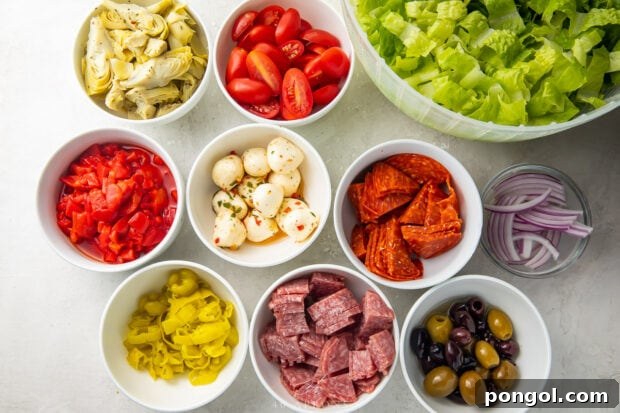 Ingredients for antipasto salad separated into small white bowls