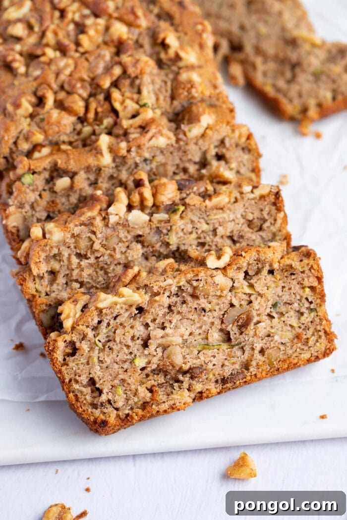 Slices of gluten free zucchini bread angled against each other on a white surface