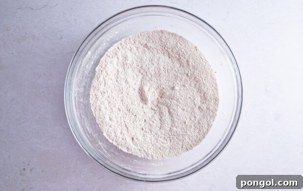 Dry ingredients for gluten free zucchini bread in large glass mixing bowl