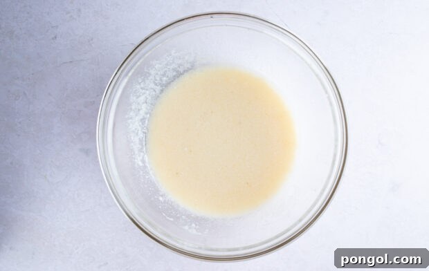Wet ingredients for gluten free zucchini bread in large glass mixing bowl