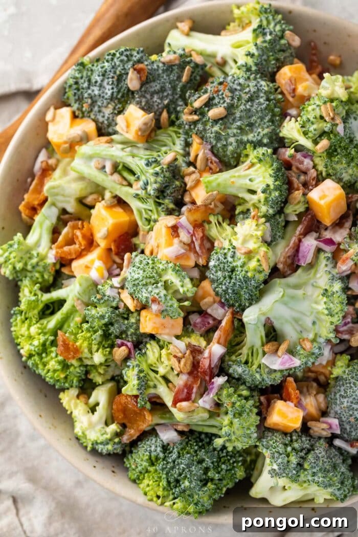 Keto broccoli salad in a large bowl on a table next to a wooden spoon