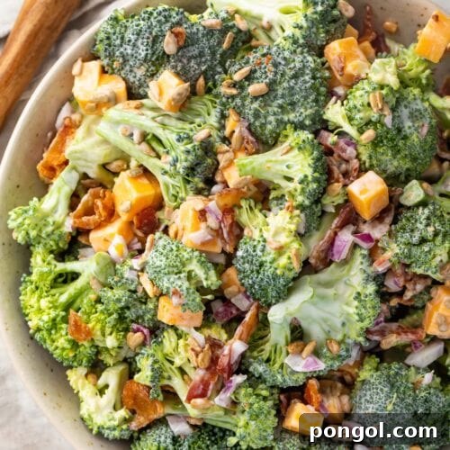 Keto broccoli salad in a large bowl next to a wooden spoon